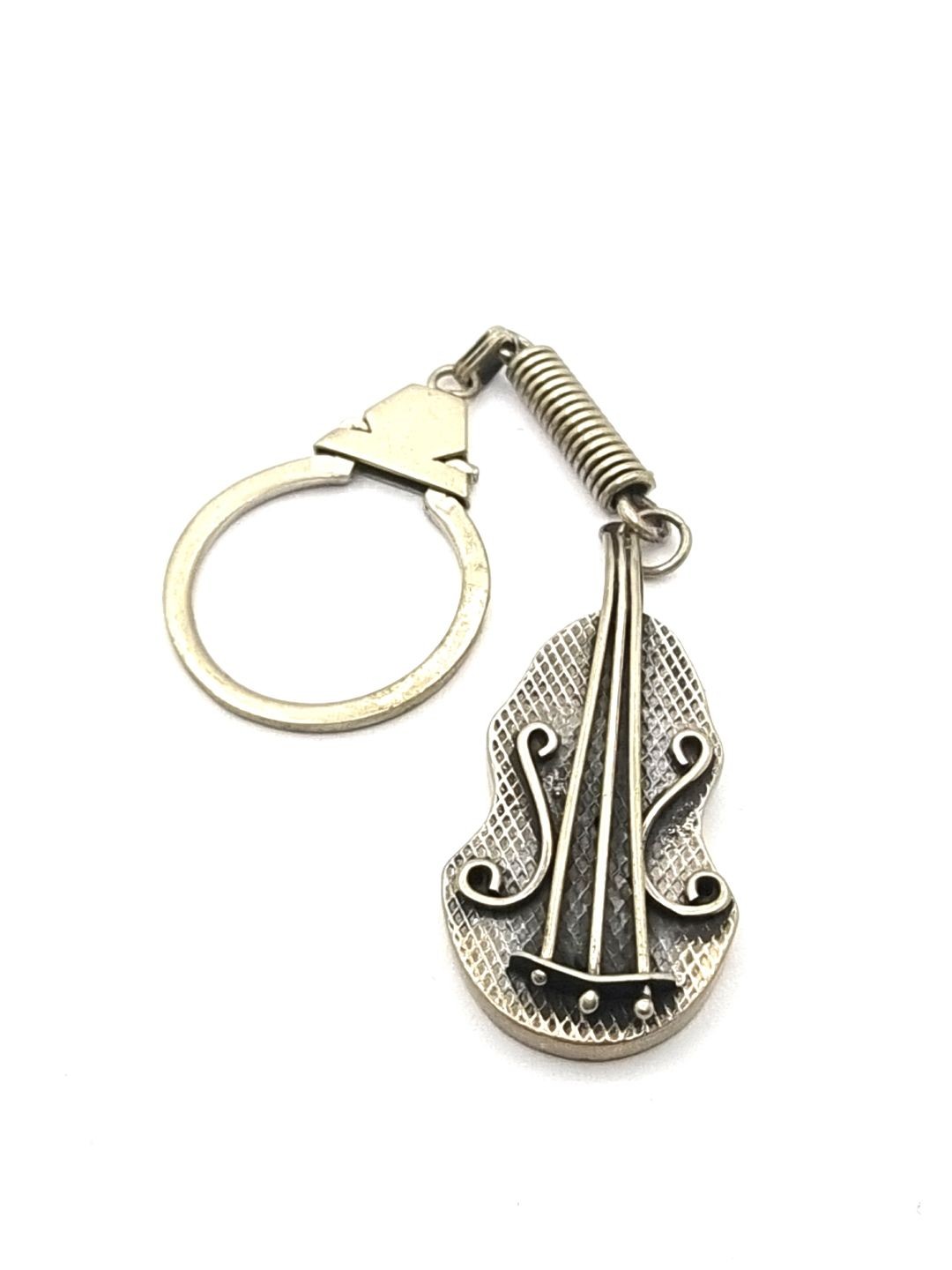 A silver medallion in the shape of a violin