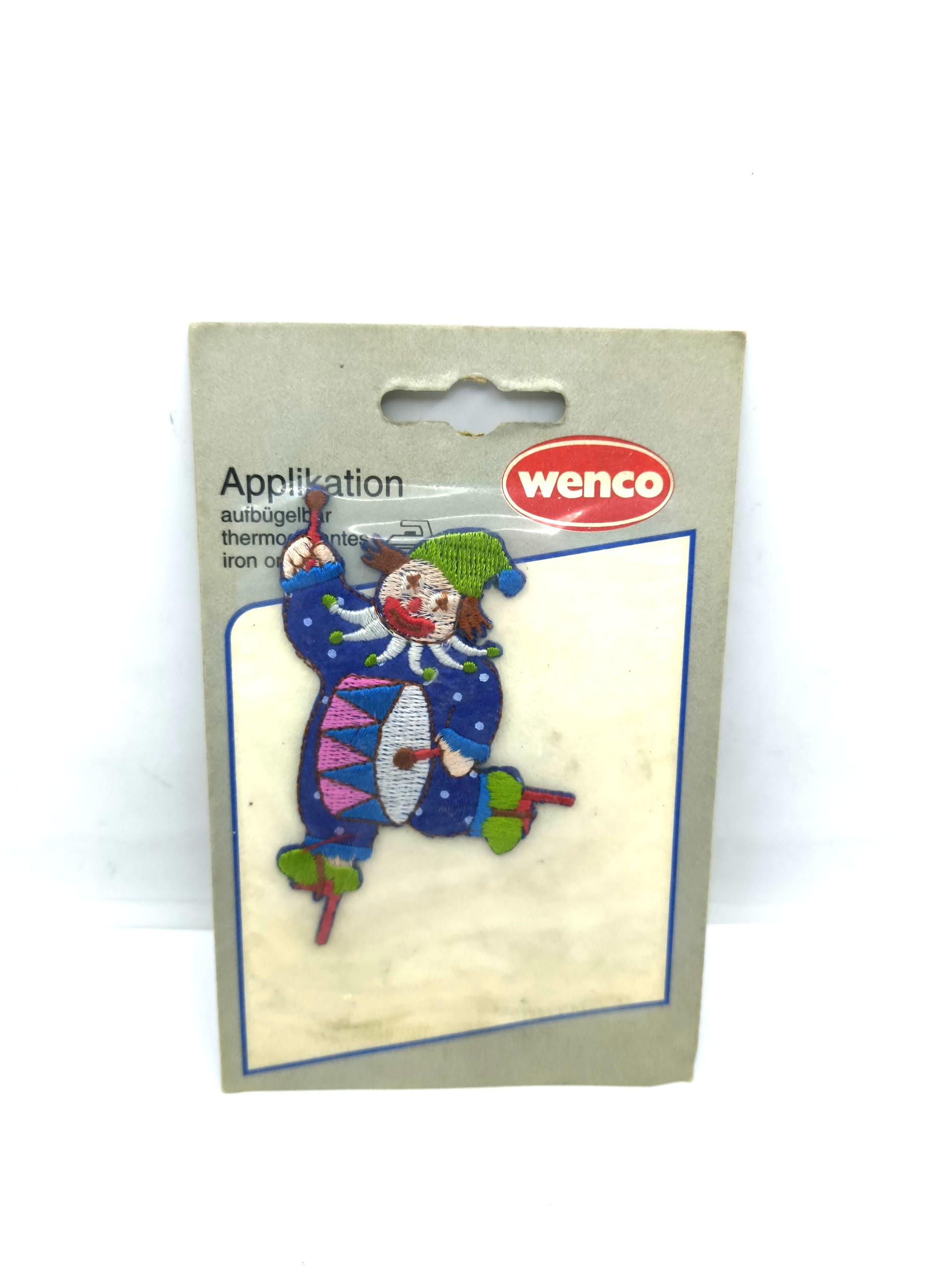 A badge in the shape of a clown playing the drum From WENCO